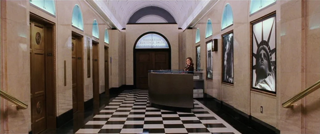 Spider-Man 2 (2004) movie still: wide — A formal office lobby features light-colored marble walls, a black and white checkerboard floor. A lone…