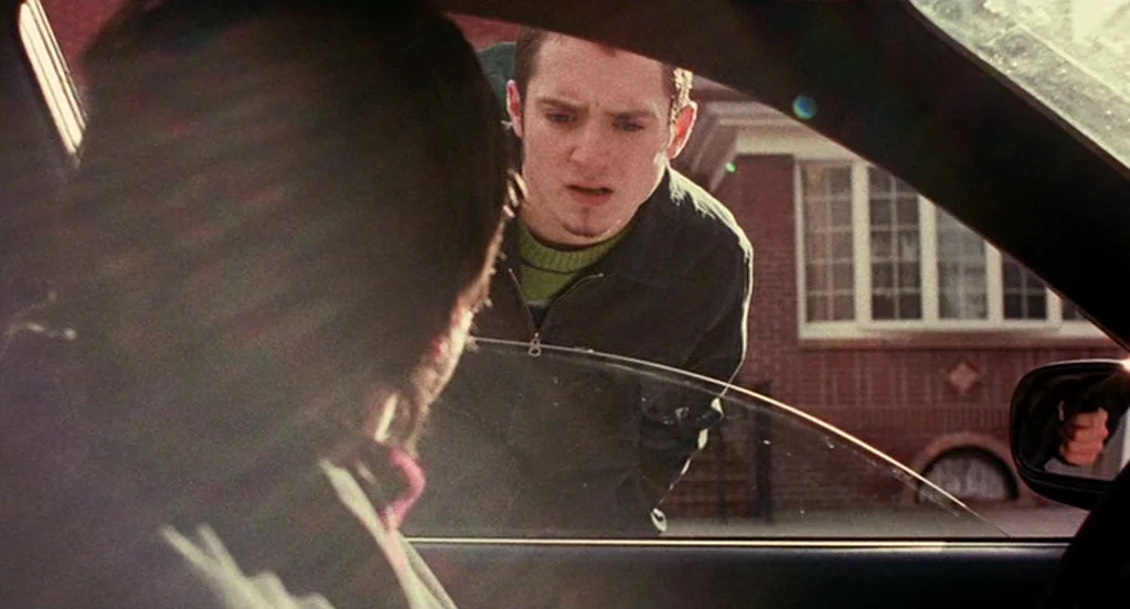 Eternal Sunshine of the Spotless Mind (2004) movie still: medium — A residential driveway with a brick house visible in the background out of focus.…