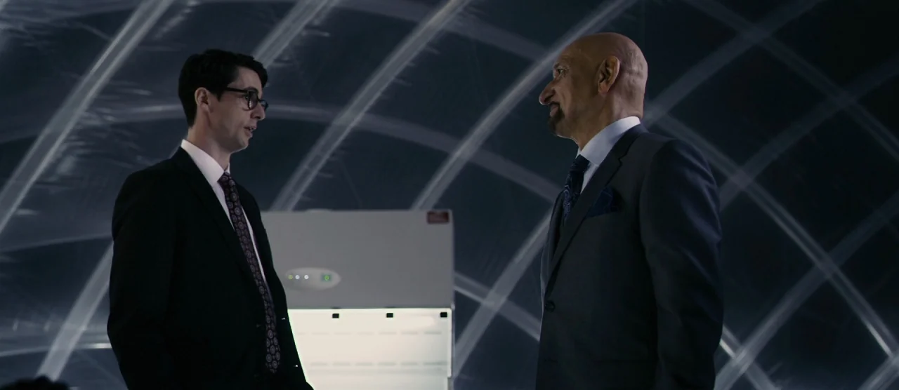 Self/less (2015) movie still: medium — A laboratory interior features a dark space enclosed by translucent plastic sheeting walls. Two men in formal…