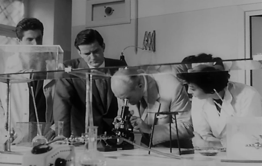 Caltiki, The Immortal Monster (1959) movie still: medium — A well-lit 1950s laboratory environment filled with various glassware and scientific…