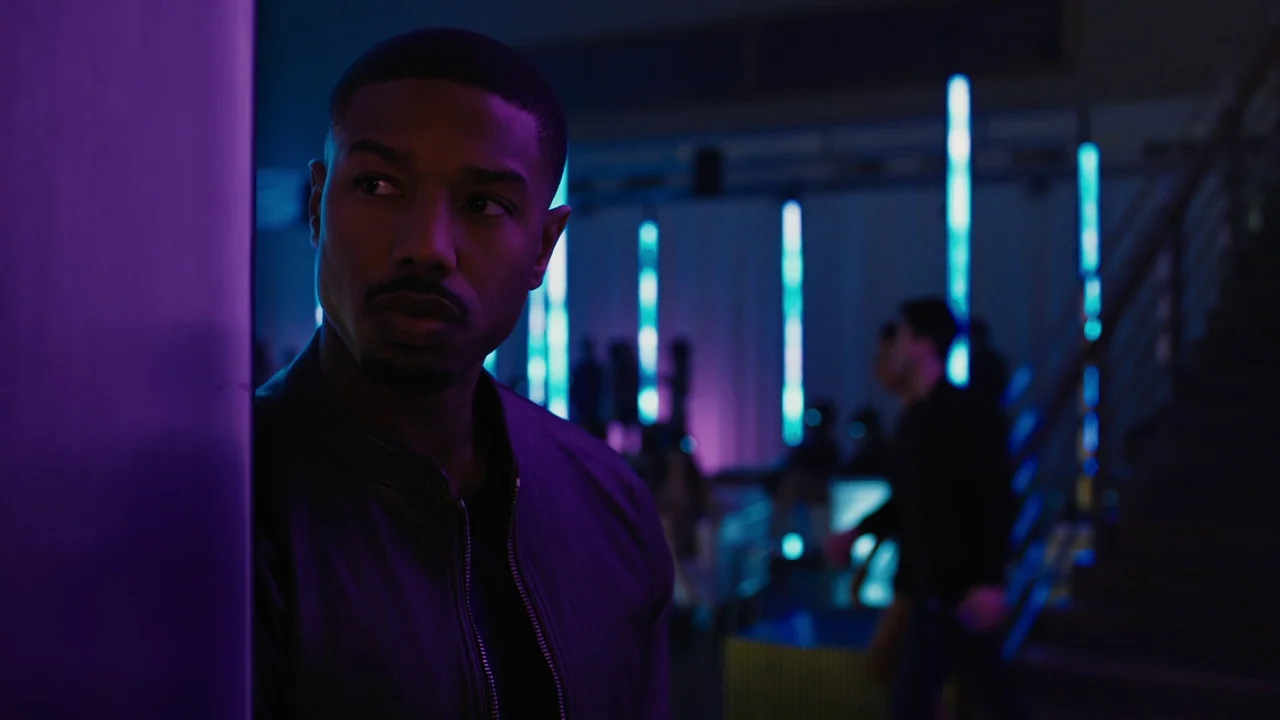 Fahrenheit 451 (2018) (2018) movie still: medium — A dark, modern nightclub features vertical blue light tubes behind the blurred dance floor crowd.…