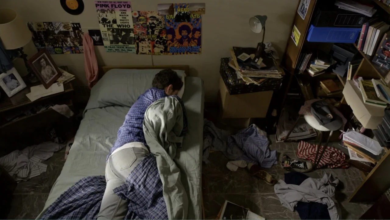 Heaven Sent (1994) movie still: medium — A cluttered bedroom filled with records, posters, and clothes strewn across the tile floor. A young man…