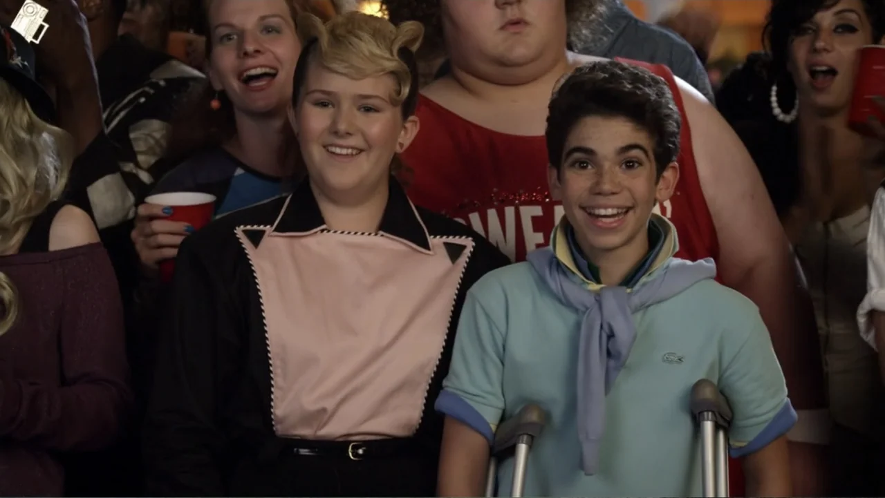 Grown Ups 2 (2013) movie still: medium — A crowded interior room filled with people attending a social gathering. Two teenagers stand in the…