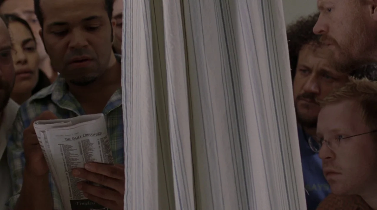 Lady in the Water (2006) movie still: medium — A group of people are gathered around a thin, vertically striped privacy curtain. A man in the…