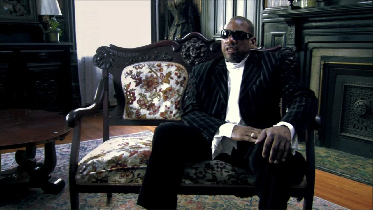 Dark Light: The Art of Blind Photographers (2009) movie still: medium — A room with dark wood paneling, an ornate fireplace, and a floral-patterned…