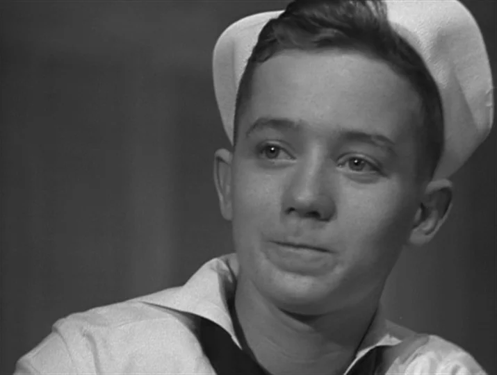 They Were Expendable (1945) movie still: closeup — A young sailor in a white cap is framed in a close-up shot. He looks towards the side while…