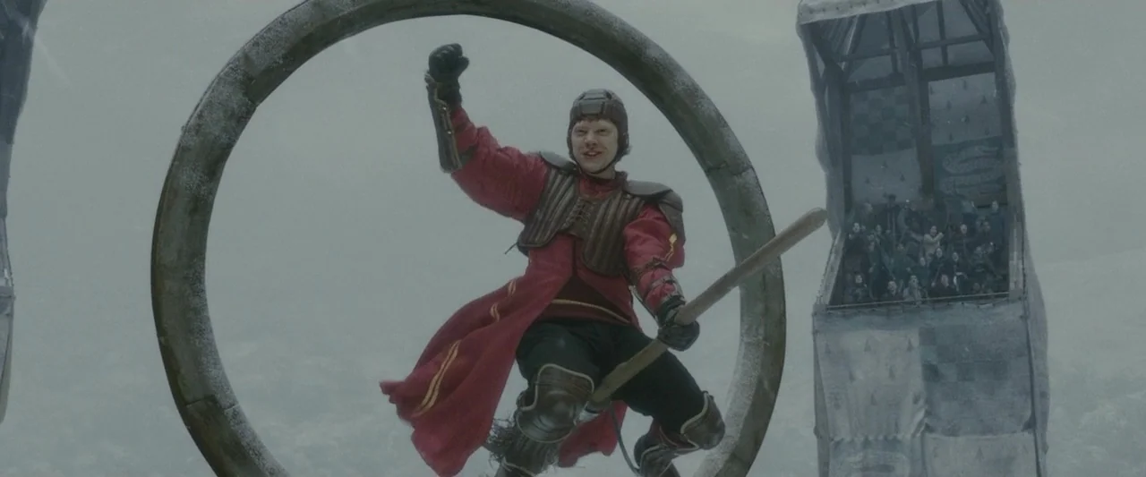 Harry Potter & The Half Blood Prince (2009) movie still: medium — A snowy outdoor arena features large circular wooden hoops suspended in mid-air. A…