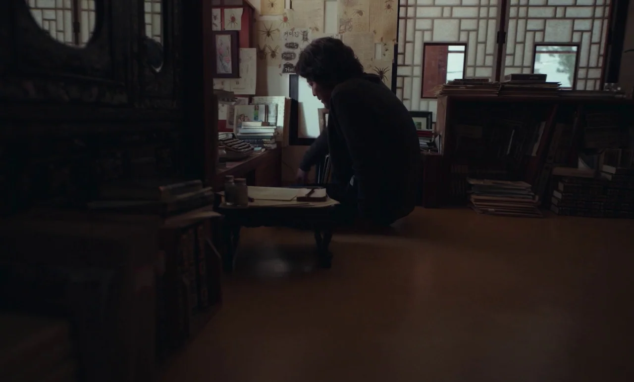 Cobweb (거미집) (2023) movie still: medium — A cluttered personal study features traditional paper-screen doors and walls covered in spider diagrams. A…