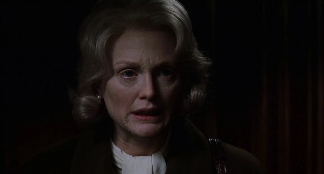 The Hours (2002) movie still: closeup — A dark, dimly lit interior space provides the backdrop for the close-up portrait. A middle-aged woman with…