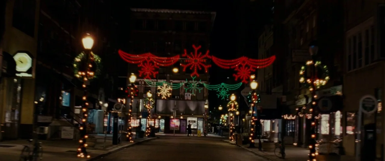 Silver Linings Playbook (2012) movie still: establishing — A nighttime city street is decorated with illuminated red and green holiday snowflake…