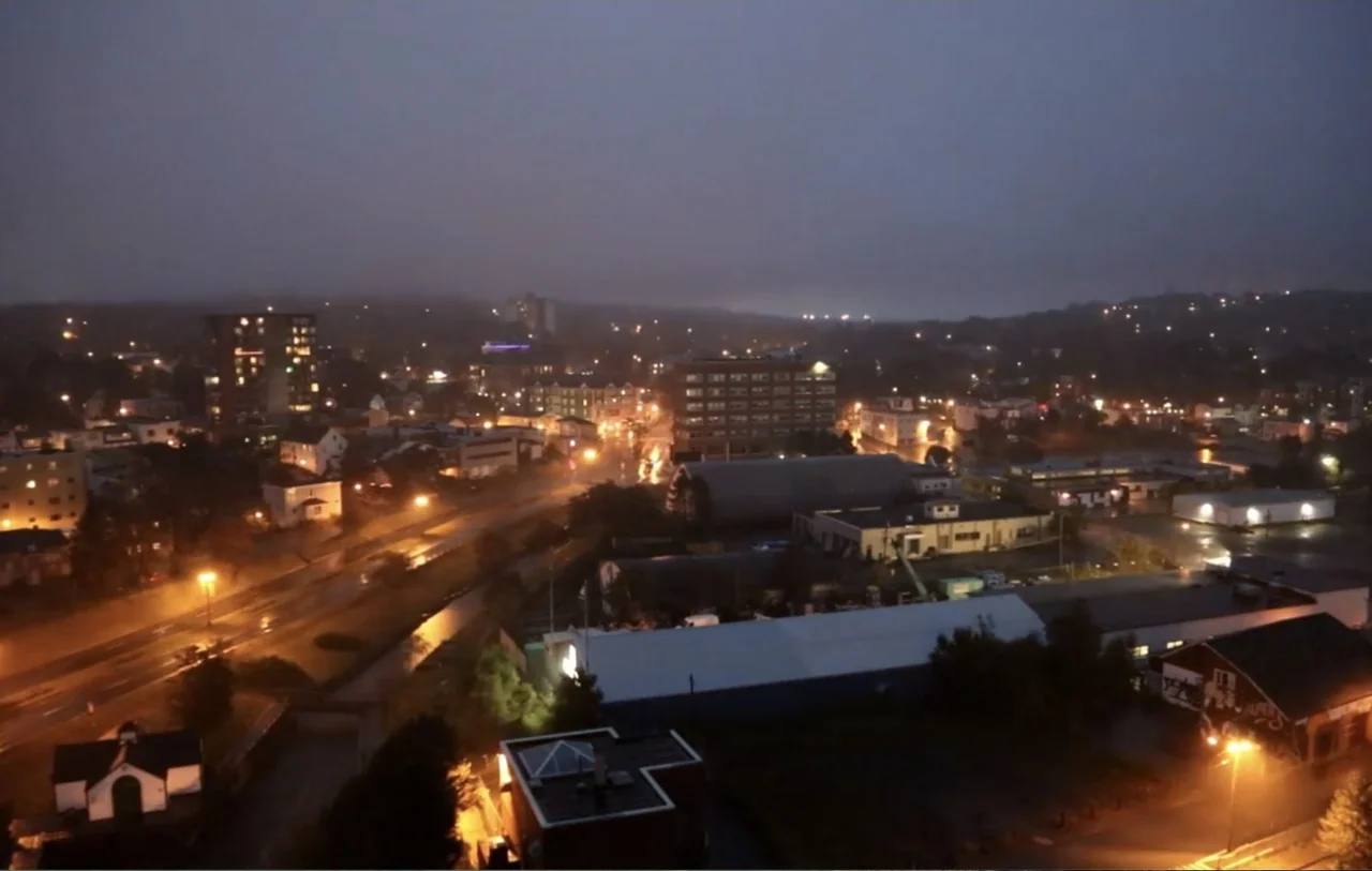 No Place to Hide (1992) movie still: establishing — An aerial view of a city at night features illuminated streets and dense buildings. Thick fog…