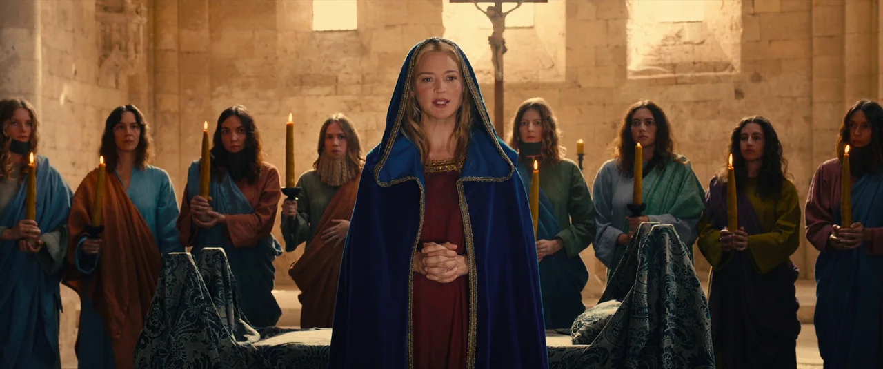 Benedetta (2021) movie still: medium — A group of women in medieval robes hold candles inside a stone church sanctuary. The central woman stands in…