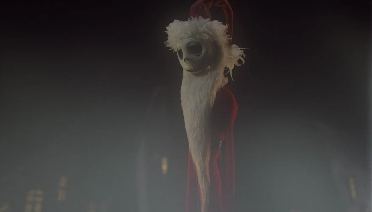 The Nightmare Before Christmas (1993) movie still: medium — A tall skeletal figure wearing a Santa suit stands in a dark misty environment. The…