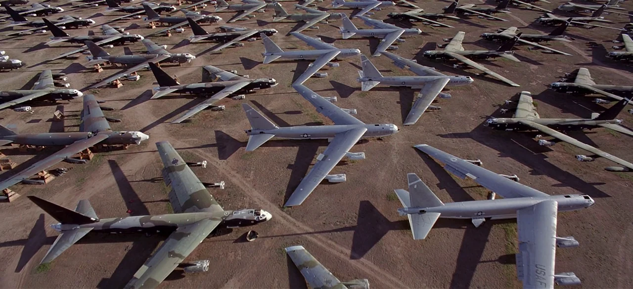 Baraka (1992) movie still: establishing — A vast, arid desert field serves as a storage site for retired military aircraft. Numerous B-52 bombers…