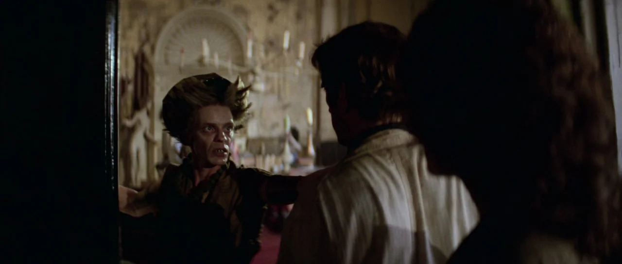 Escape From New York (1981) movie still: medium — A dimly lit room in a mansion features ornate architectural details and candles. A woman stands in…