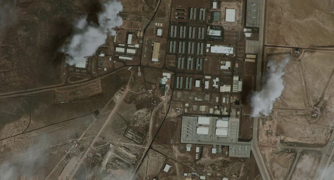Zero Dark Thirty (2012) movie still: establishing — An aerial perspective shows a sprawling military complex situated in an arid desert region. Two…