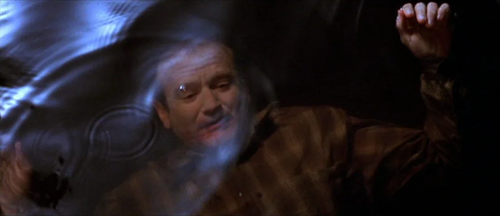 Insomnia (2002) movie still: closeup — An older man is submerged under the surface of dark water at night. He looks up toward the rippling water…