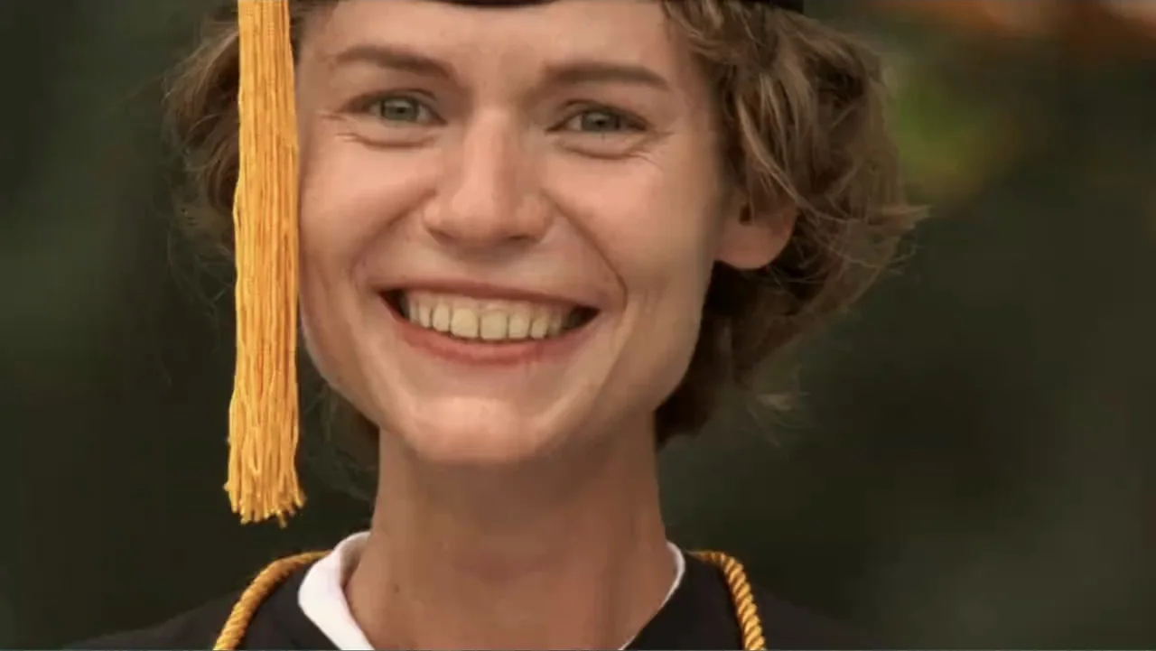Temple Grandin (2010) movie still: closeup — An outdoor graduation setting with a blurred background of greenery and light. A young woman in a…