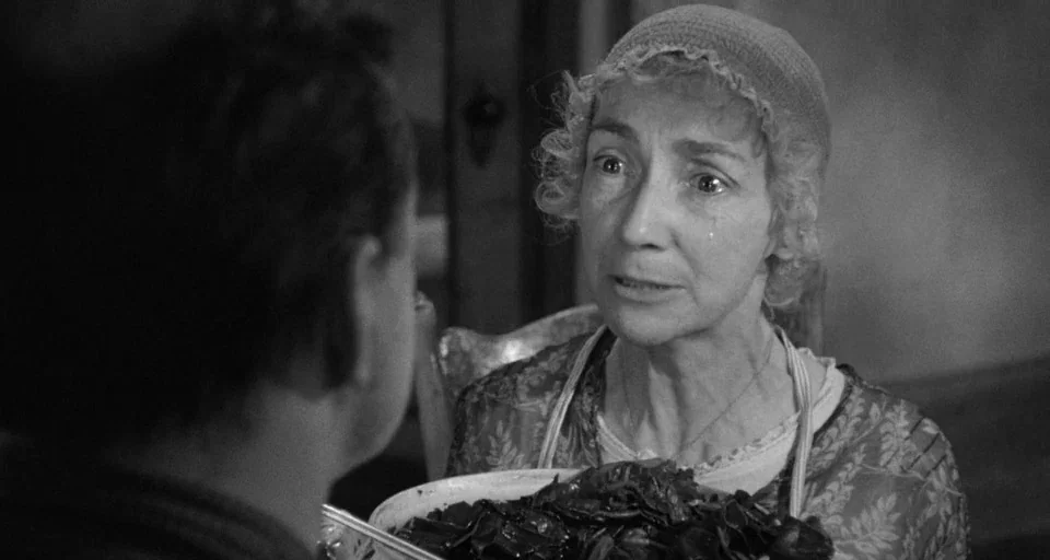 Baby Doll (1956) movie still: medium — An interior space with a woman holding a large bowl while looking at someone. The woman has an expression of…