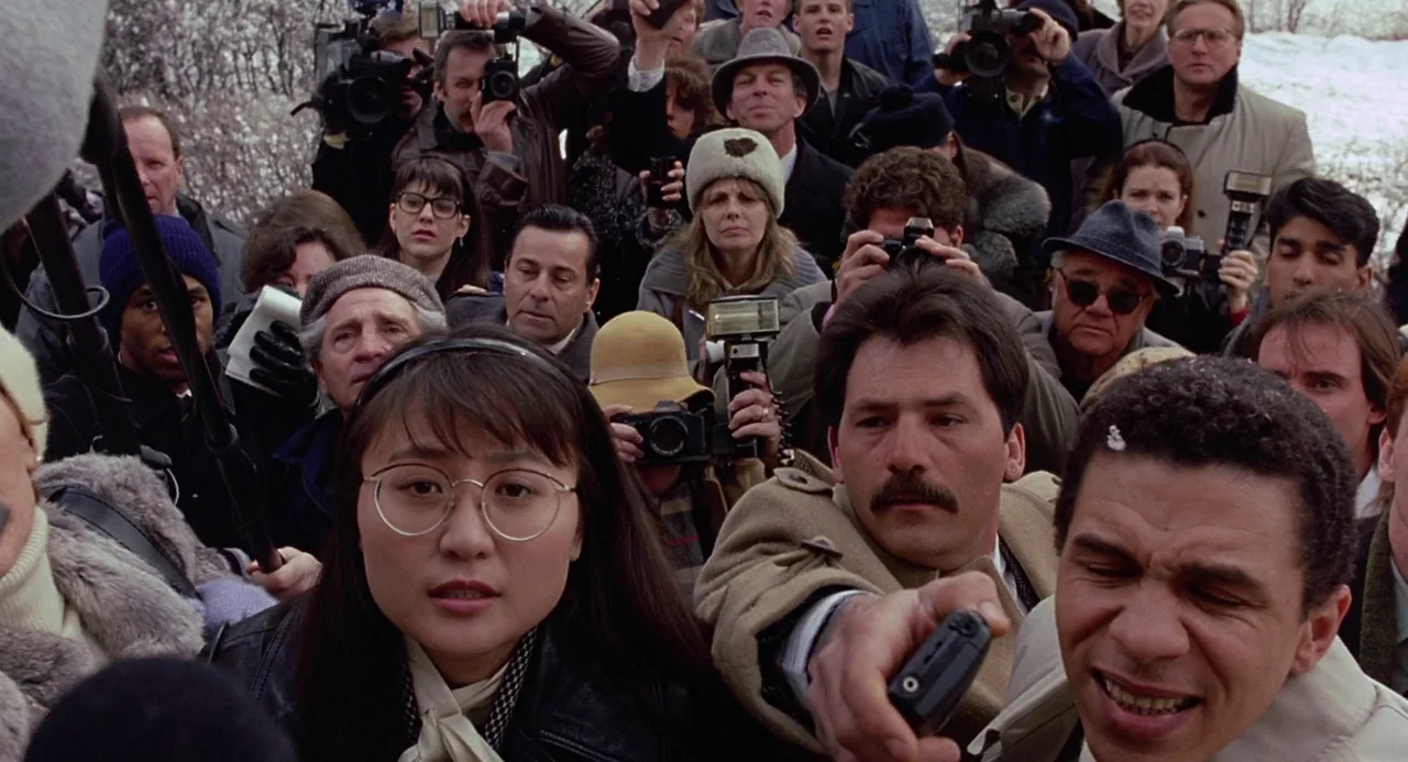 To Die For (1995) movie still: medium — A dense crowd of photographers and reporters stands closely together outdoors. Many individuals are holding…