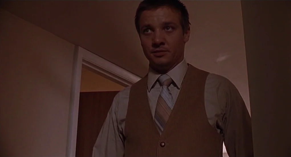 The Heart Is Deceitful Above All Things (2004) movie still: medium — A dimly lit indoor space features a man standing in a doorway. The subject…