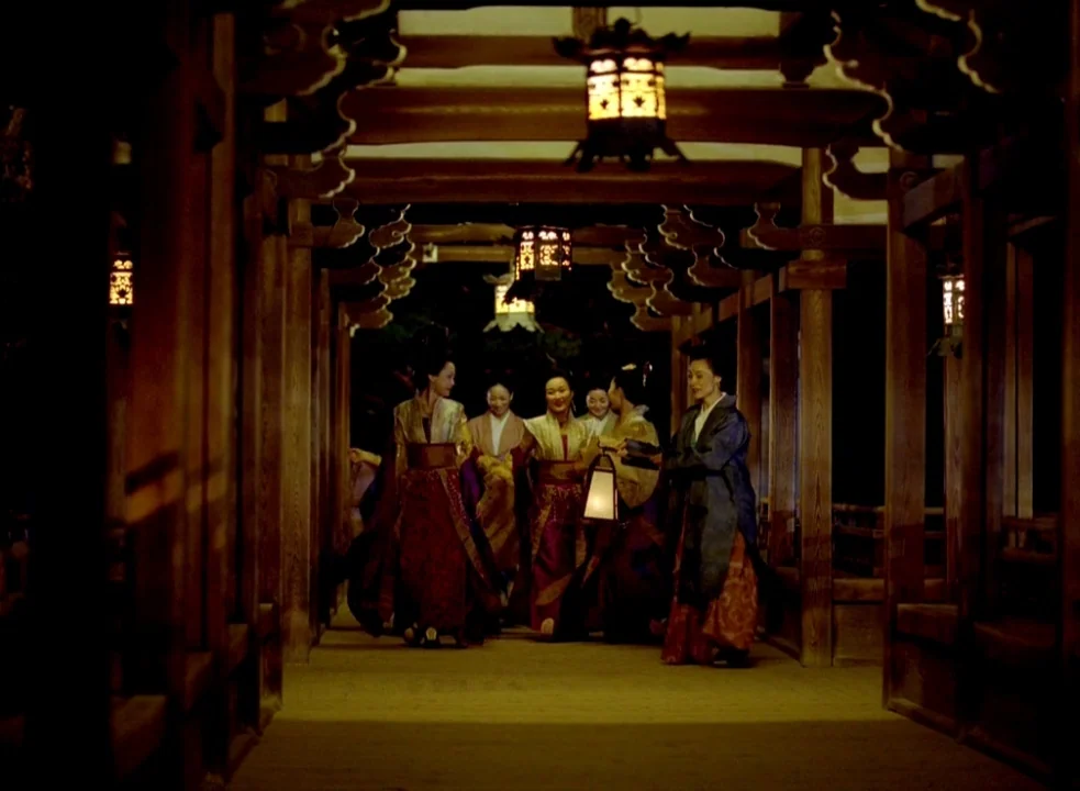 The Assassin (2015) movie still: fullbody — A dark, wood-paneled corridor features intricate carved ceiling beams and hanging ornamental lanterns.…