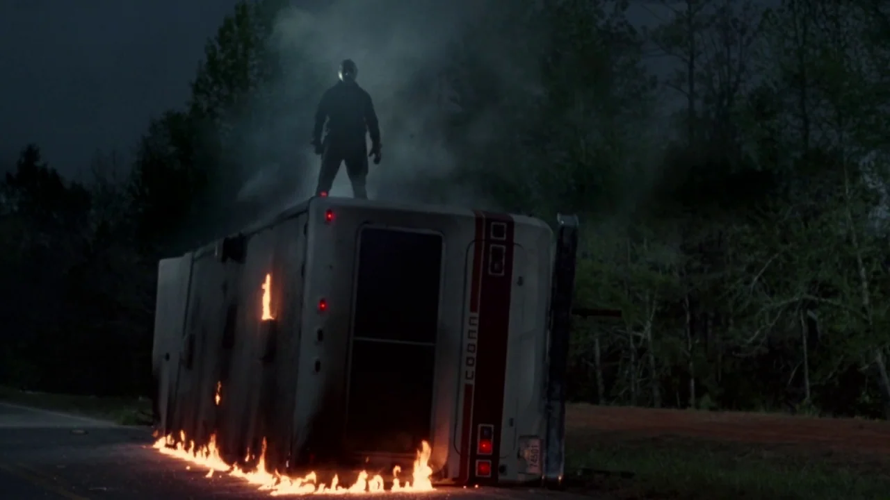 Friday the 13th Part VI: Jason Lives (1986) movie still: wide — A dark rural road at night features a burning recreational vehicle tipped onto its…