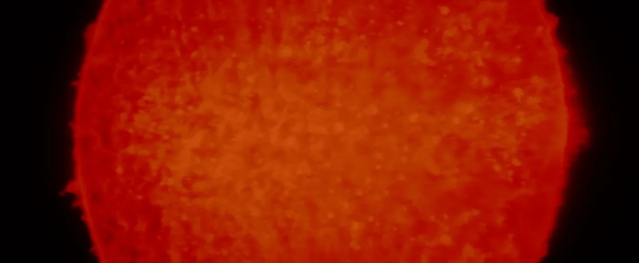 Superman (1978) movie still: closeup — A close-up view of the glowing red surface of a star in space. The surface is textured with variations in…