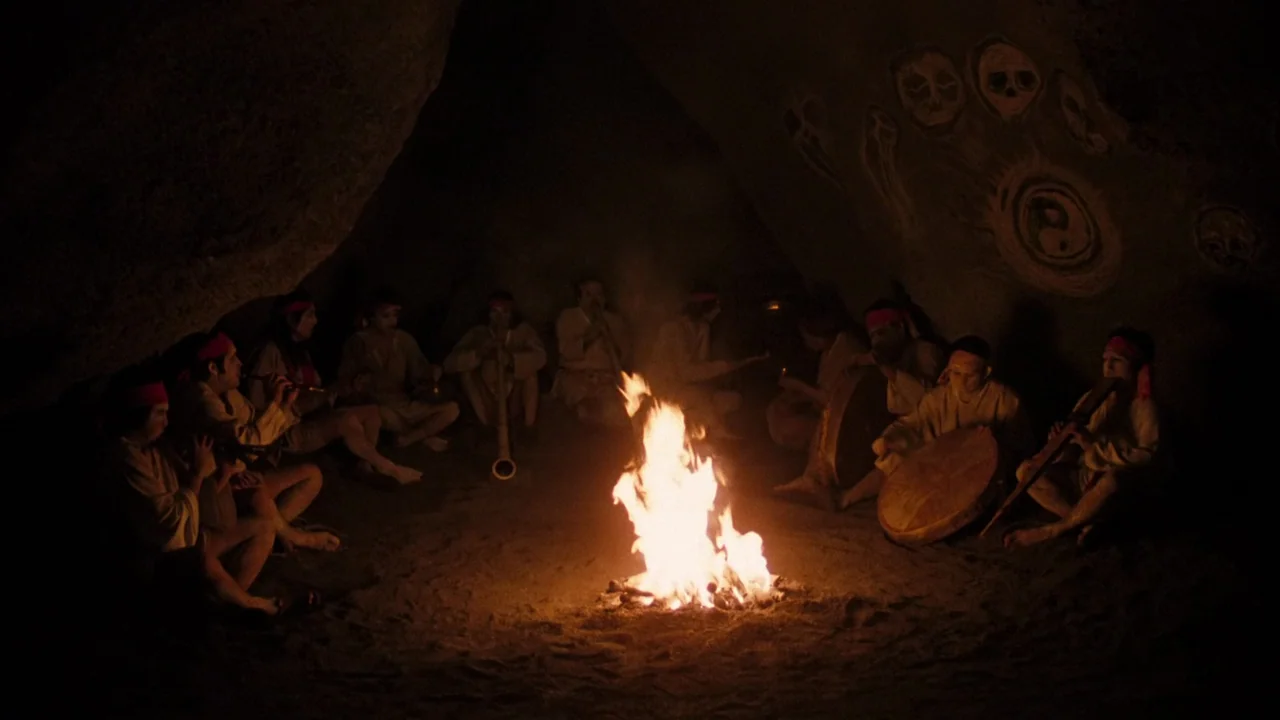 Altered States (1980) movie still: wide — A cave interior with primitive circular symbols and skulls painted on the stone walls. A group of…