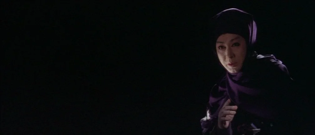 An Actor’s Revenge (1963) movie still: medium — A woman stands in a void with no visible background or architectural details. She faces slightly…