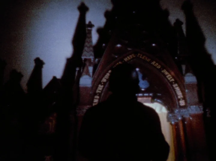 Scorpio Rising (1963) movie still: medium — An ornate gothic stone archway features carved religious text illuminated by a glowing light source. A…