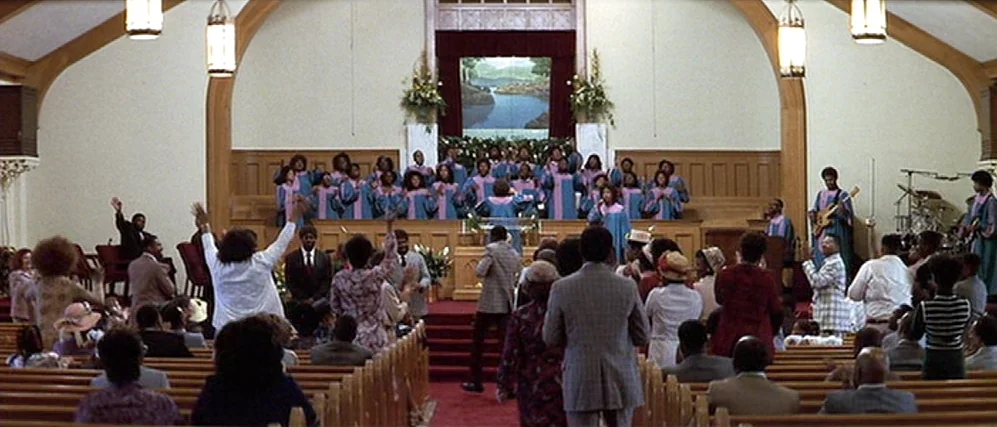 The People vs. Larry Flint (1996) movie still: wide — A spacious church interior features wooden pews and a raised altar area with singers. A large…