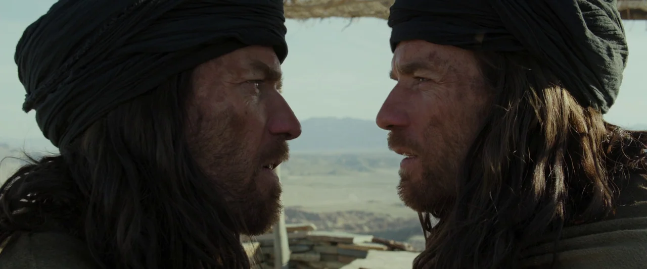 Last Days in the Desert (2015) movie still: medium — A dry, dusty landscape provides the backdrop for two identical men in head wraps. The pair…