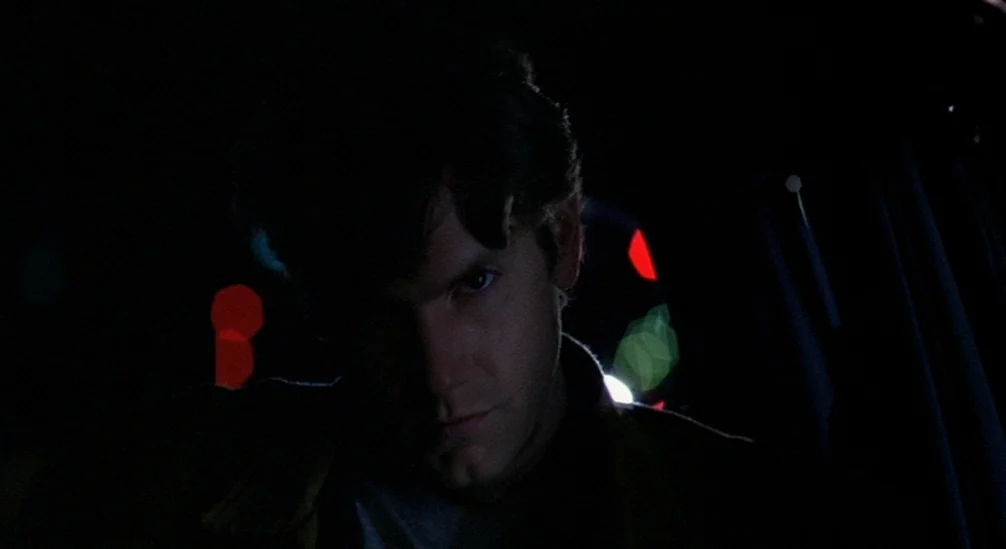 New Nightmare (1994) movie still: closeup — The interior of a vehicle at night with darkness encompassing the surroundings. A man sits in the driver…