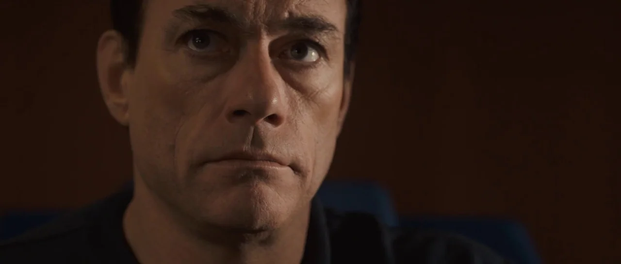 Universal Soldier: Regeneration (2009) movie still: closeup — A man's face is illuminated in a dark interior space with a blank background. He gazes…