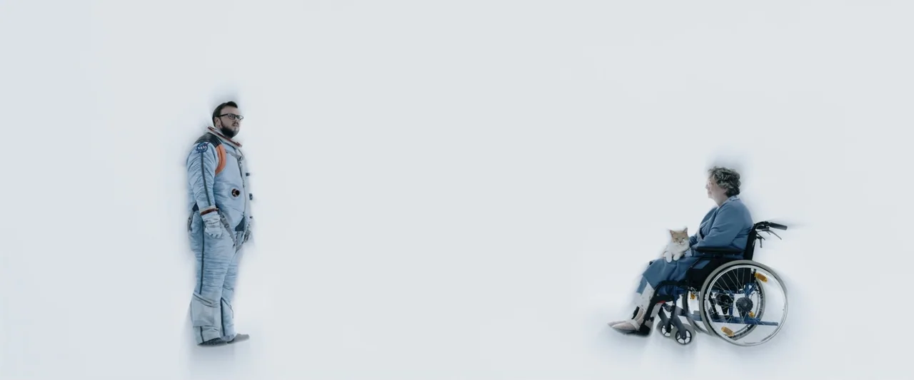 Moonfall (2022) movie still: wide — An expanse of stark white surfaces surrounds two individuals positioned at opposite ends. A man in a space suit…