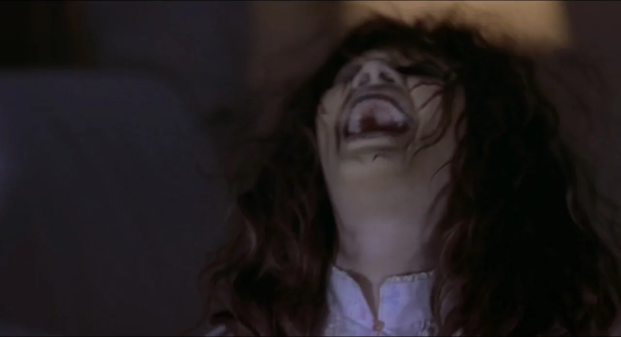 Scary Movie 2 (2001) movie still: closeup — A dark indoor setting with limited illumination on the subjects face. A woman with long brown hair tilts…