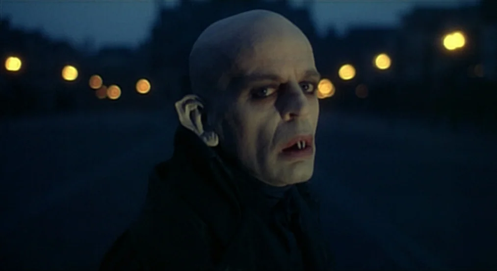 Nosferatu the Vampyre (Nosferatu Phantom Der Nacht) (1979) movie still: closeup — A night scene on an empty city street with blurred yellow bokeh…