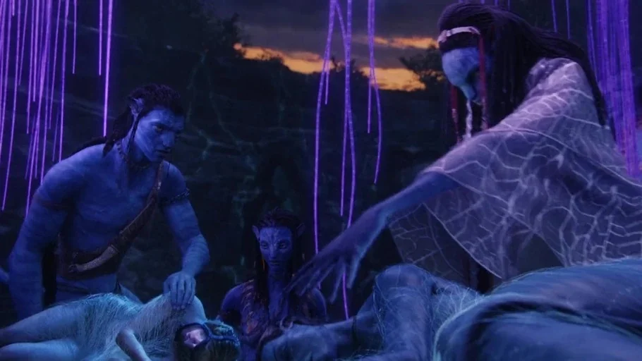 Avatar (2009) movie still: medium — A group of tall, blue-skinned figures surrounds a person lying on the ground. They are positioned under glowing…