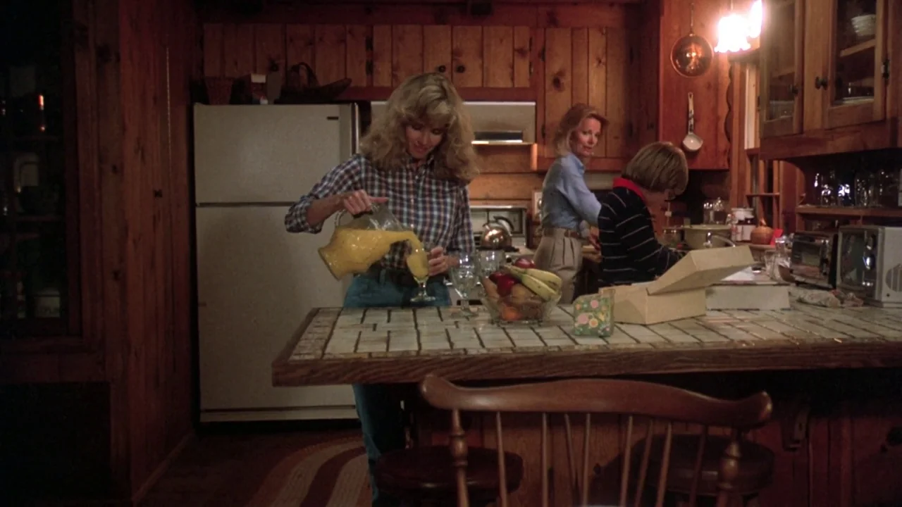 Friday the 13th: The Final Chapter (1984) movie still: medium — A rustic kitchen features dark wood paneled walls and a light-tiled island…