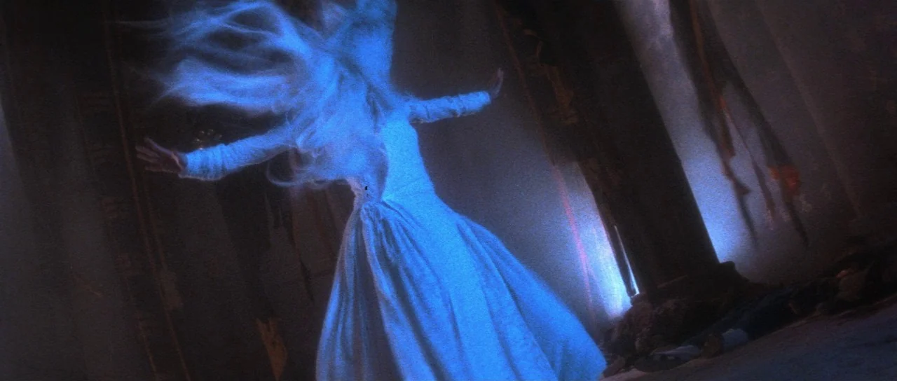 The Bride With White Hair (1993) movie still: fullbody — A dimly lit narrow corridor with dark walls and a stone pillar structure. A woman wearing a…