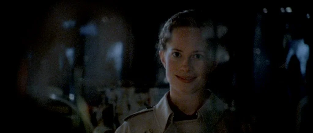 Reconstruction (2003) movie still: closeup — The interior of a darkened store at night with indistinct blurred objects in view. A young woman in a…