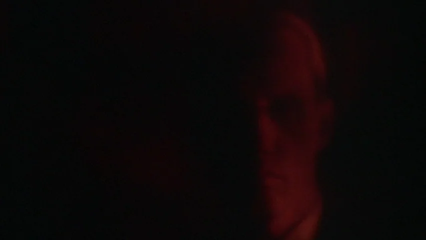 Once Upon A Time In America (1984) movie still: closeup — A dimly lit room provides a backdrop for a person's partially obscured face. A man gazes…