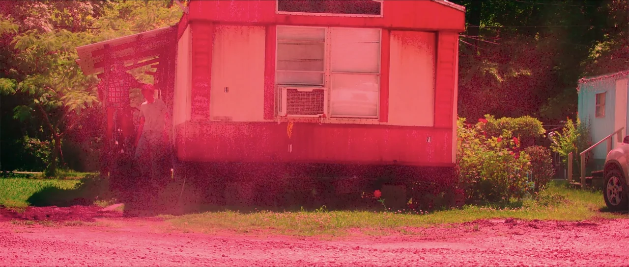 68 Kill (2017) movie still: wide — A worn mobile home with a prominent window air conditioning unit sits in a yard. A person stands beneath the…