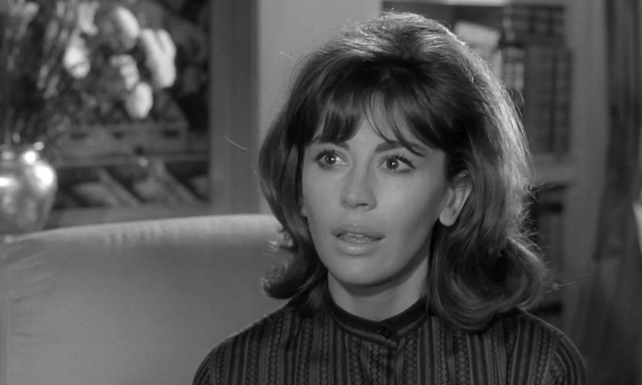 Seance on a Wet Afternoon (1964) movie still: closeup — A 1960s interior with a soft-focus background featuring a floral arrangement. A woman with…