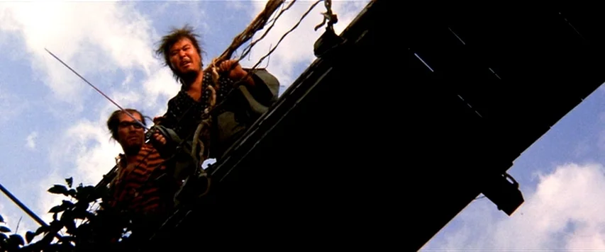 Lone Wolf and Cub: Sword of Vengeance (1972) movie still: medium — Two men stand on a suspension bridge against a bright, cloudy sky. The men grasp…