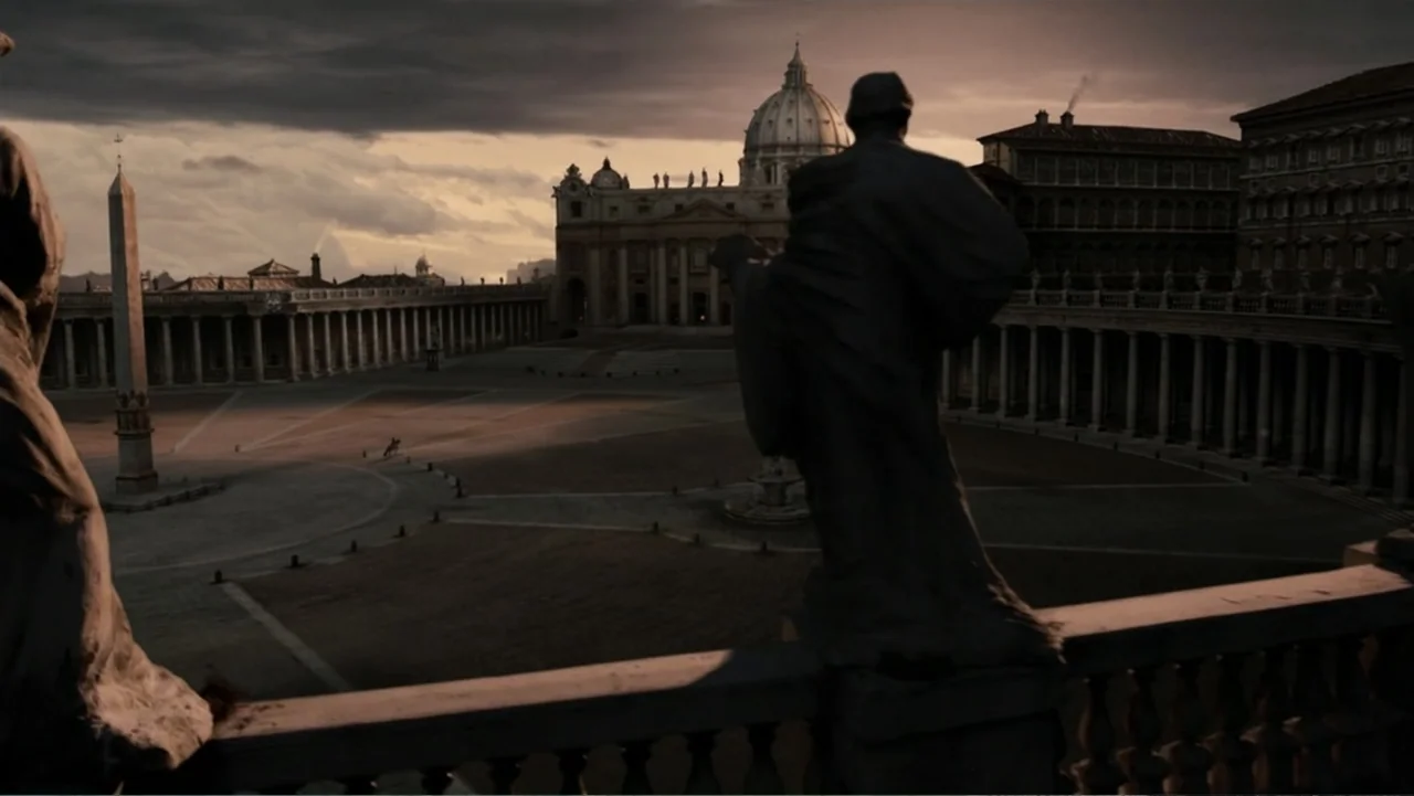 Van Helsing (2004) movie still: establishing — A wide view of a vast stone courtyard featuring grand columns and a basilica dome. The area is devoid…