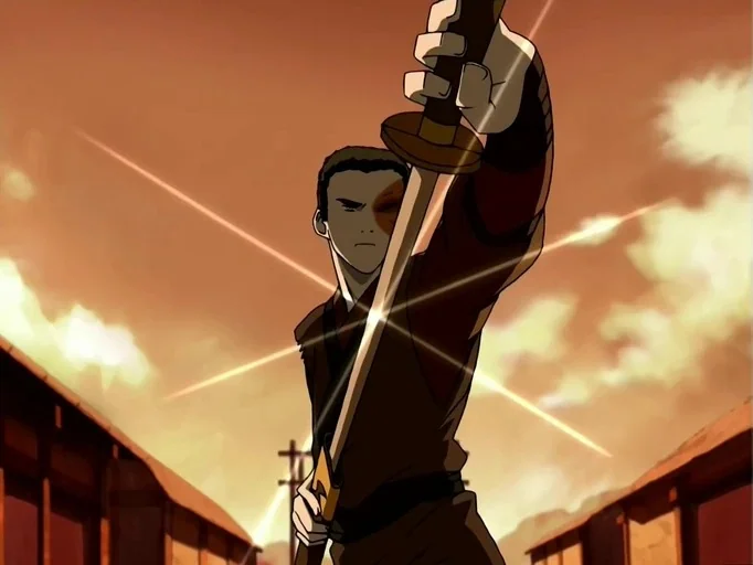 Avatar: The Last Airbender (2005) movie still: medium — An open outdoor area is lit by the warm glow of a setting sun. A young man holds a straight…