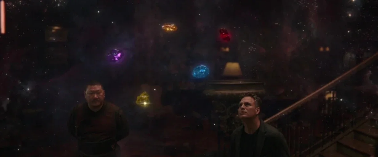 Avengers: Infinity War (2018) movie still: medium — A dark indoor space is transformed by a cosmic projection of floating infinity stones. Two men…