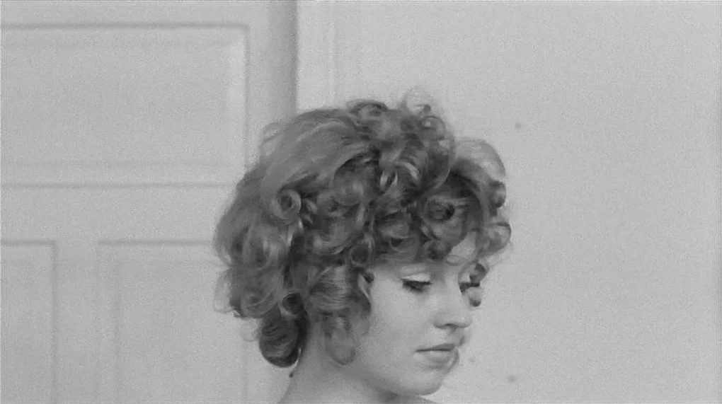 Love Is Colder Than Death (1969) movie still: closeup — An interior space features a plain white wall and a white paneled door. A young woman with…